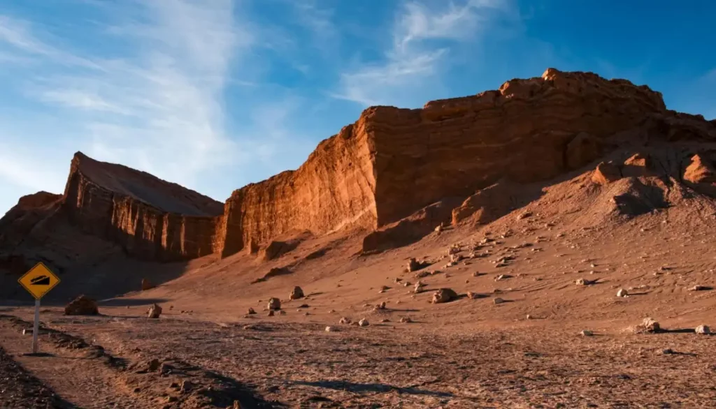 Paisagem desértica no Vale da Lua, no Atacama, com formações rochosas imponentes e um céu azul claro, mostrando a beleza árida e única do deserto.