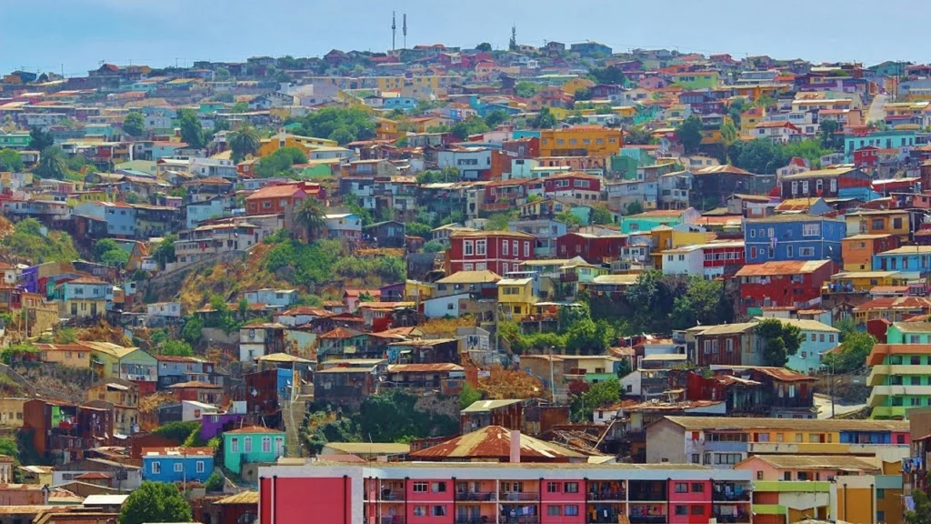 Casas coloridas espalhadas pelas colinas de Valparaíso, Chile, com sua arquitetura vibrante e charme único, patrimônio cultural da UNESCO.