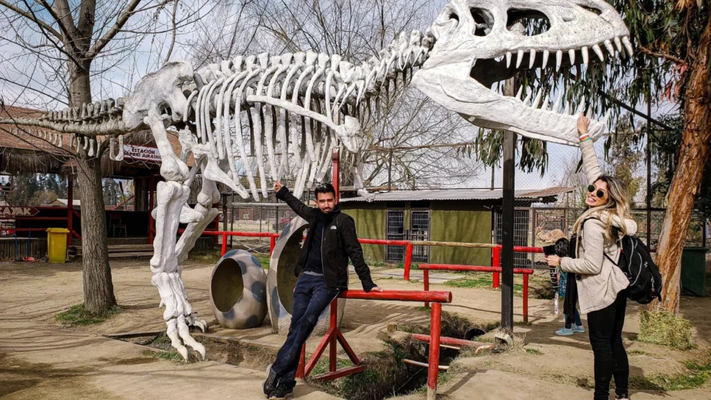 Visitantes posam com o esqueleto de dinossauro no Parque Safari em Rancagua.